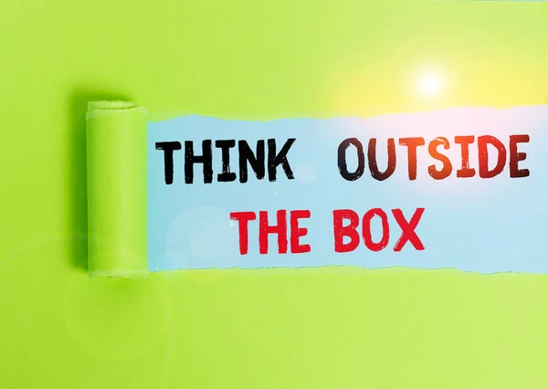 ป้ายข้อความแสดง Think Outside The Box รูปแบบภาพ เป็นความคิดที่แตกต่างกันที่ไม่ซ้ํากันนํากระดาษแข็งระดมสมองซึ่งถูกฉีกตรงกลางวางอยู่เหนือพื้นหลังตารางธรรมดา . — ภาพถ่ายสต็อก