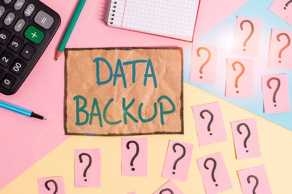 Writing note showing Data Backup. Business photo showcasing copy of important data that is stored on an alternative location Mathematics stuff and writing equipment above pastel colours background.