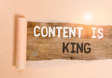 El yazısı içeriği kraldır. Kavram, içeriğin, bir web sitesi kartonunun başarısı için merkezi olduğuna inanmaktır. Ortadan ikiye bölünmüş, ahşap klasik bir masanın üzerine yerleştirilmiş..