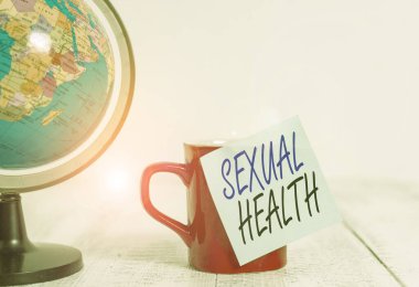 Conceptual hand writing showing Sexual Health. Business photo showcasing positive and respectful approach to sexual relationships Globe map coffee cup sticky note lying vintage wooden table.