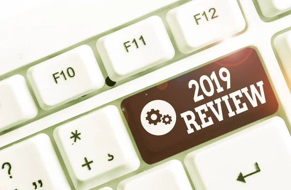 Text rukopisu 2019 Review. Koncept význam Nové trendy a vyhlídky v cestovním ruchu nebo službách pro rok 2019 Bílá PC klávesnice s prázdným poznámkovým papírem nad bílým pozadím klíčové kopírovací prostor. — Stock fotografie