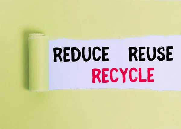 Sinal de texto mostrando Reduzir Reutilizar Reciclagem. Maneiras de fotos conceituais podem eliminar o desperdício proteger seu ambiente Cartão rasgado no meio colocado acima de um pano de fundo de mesa simples . — Fotografia de Stock