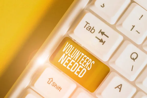 Handwriting text writing Volunteers Needed. Concept meaning need work or help for organization without being paid White pc keyboard with empty note paper above white background key copy space. — Stock Photo, Image