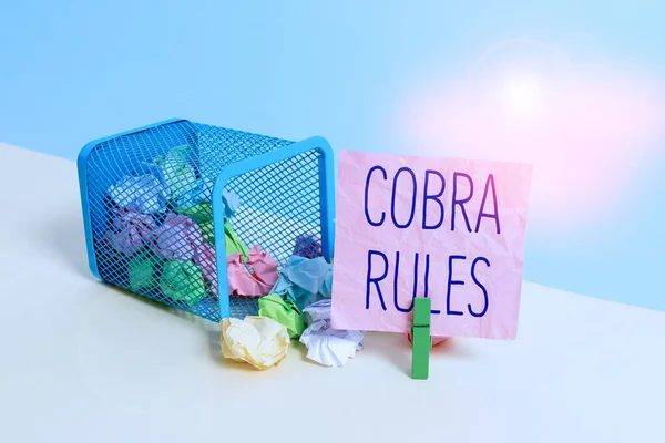 Conceptual hand writing showing Cobra Rules. Business photo text continuing group health insurance coverage after a job loss Trash bin crumpled paper clothespin reminder office supplies.