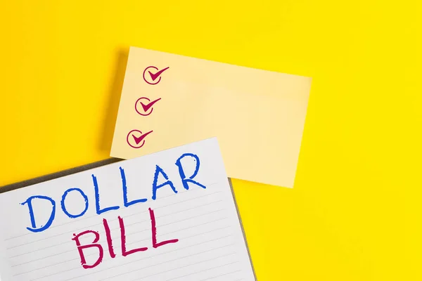 Conceptueel handschrift met Dollar Bill erop. Zakelijke foto tekst een stuk papiergeld ter waarde van een dollar Federal Reserve nota Leeg oranje papier met kopieerruimte op de gele tafel. — Stockfoto