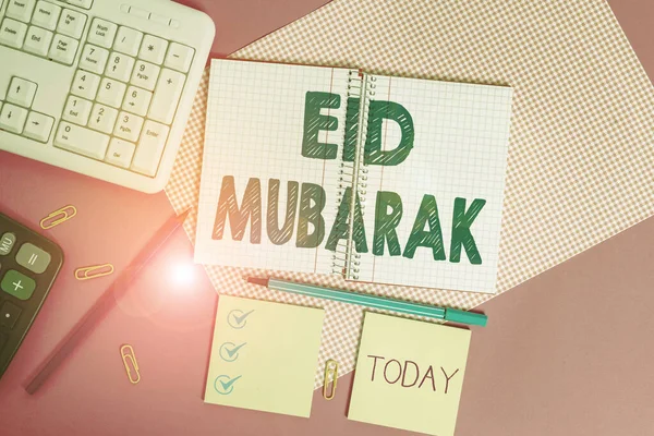 Texto de escritura de palabras Eid Mubarak. Concepto de negocio para el saludo musulmán tradicional reservado para los festivales sagrados Equipos de escritura y artículos informáticos colocados sobre la mesa lisa de colores . — Foto de Stock