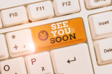 Kavramsal el yazısı yakında görüşürüz diyor. Biriyle vedalaşmak ve tekrar buluşmaya gitmek için kullanılan iş fotoğrafı metni beyaz arkaplanın üzerinde nota kağıdı ile birlikte.