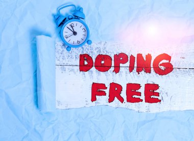 Doping Free 'yi gösteren kavramsal el yazısı. Ticari fotoğraf metni, spor saatini yasadışı olarak geliştirmek için herhangi bir madde kullanmadığını kanıtladı ve tahta bir klasik masa zemininde karton yırtıldı..