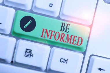 El yazısı. Bilgilendirilin. Beyaz arkaplan anahtar boşluğunun üzerinde boş not kağıdı olan bir konu veya durum bilgisine sahip olmak veya göstermek anlamına gelir.