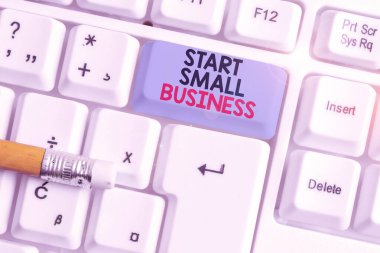Start Small Business 'ı gösteren bir not yazıyorum. Yeni Girişimci Arzusu Fotoğrafı Beyaz PC klavyeli Yeni Girişim Endüstrisi Beyaz PC Klavyesi.