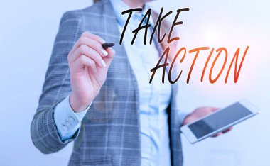 El yazısı Take Action. Belirli bir sonuç elde etmek için anlamlı bir şey yapma kavramı. İş kadını boş alanı kalem ve cep telefonuyla işaret ediyor..