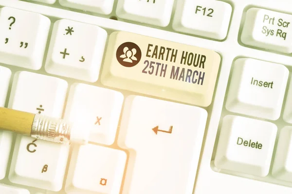 地球時間3月25日を示す概念的な手書き。惑星へのシンボルコミットメントを示すビジネス写真組織化された世界基金白の背景の上にノートPCのキーボード. — ストック写真