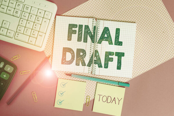 Word writing text Final Draft. Business concept for final version of something after a lot of editing and rewriting Writing equipments and computer stuffs placed above colored plain table.