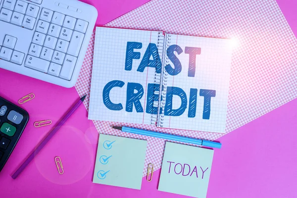 Słowo pisanie tekstu Fast Credit. Koncepcja biznesowa Aplikuj o szybki kredyt demonstracyjny, który pozwala pominąć kłopotów Pisanie sprzętu i rzeczy komputerowych umieszczonych nad kolorowy zwykły stół. — Zdjęcie stockowe
