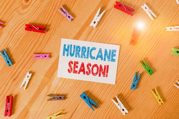Handwriting text writing Hurricane Season. Concept meaning time when most tropical cyclones are expected to develop Colored clothespin papers empty reminder wooden floor background office.