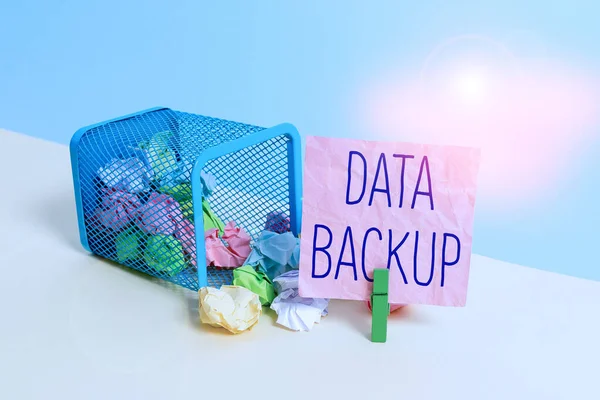 Conceptual hand writing showing Data Backup. Business photo text copy of important data that is stored on an alternative location Trash bin crumpled paper clothespin reminder office supplies.