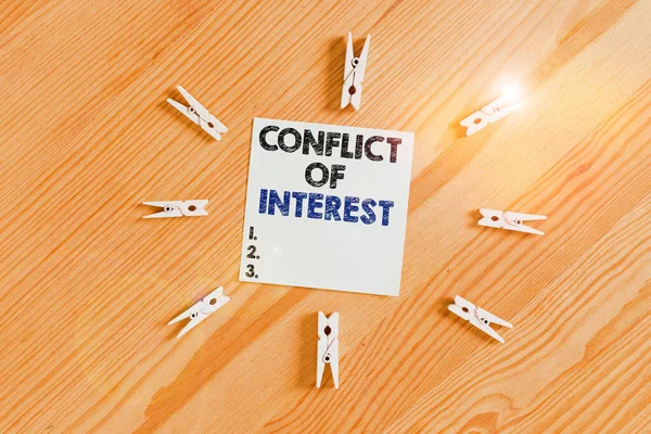 Word writing text Conflict Of Interest. Business concept for disagreeing with someone about goals or targets Colored clothespin papers empty reminder wooden floor background office. — Stok fotoğraf