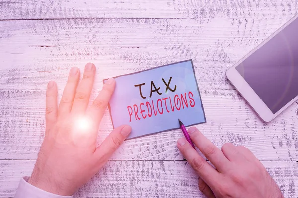 Conceptual hand writing showing Tax Refund. Business photo text refund on tax when the tax liability is less than the tax paid Hand hold note paper near writing equipment and smartphone.