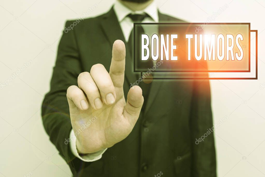 Text sign showing Bone Tumors. Conceptual photo can be either benign or malignant growths found in the bone Male human with beard wear formal working suit clothes raising one hand up.