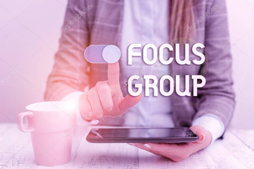 Text sign showing Focus Group. Conceptual photo showing assembled to participate in discussion about something Business woman sitting with mobile phone and cup of coffee on the table.
