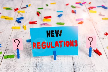 Yeni Yönetmelik Sorusu 'nu gösteren metin işareti. Kavramsal fotoğraf kuralları devlet düzenini kontrol altına aldı. Bir şeyler yapılıyordu. Tahta masaya raptiyeler konmuş karalanmış ve parçalanmış kağıtlar..