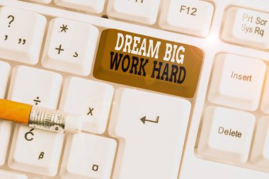 Dream Big Work Hard'ı gösteren bir metin işareti. Kavramsal fotoğraf Kendinize inanın ve beyaz arka plan tuşu kopyalama alanı üzerinde boş not kağıdı ile rüyalar ve hedefler Beyaz pc klavye izleyin.