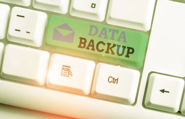 Handwriting text Data Backup. Concept meaning copy of important data that is stored on an alternative location White pc keyboard with empty note paper above white background key copy space. — Stock Photo, Image