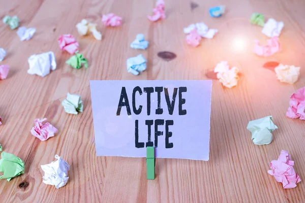 Writing note showing Active Life. Business photo showcasing way of life that integrates physical activity into your everyday Colored crumpled papers wooden floor background clothespin.