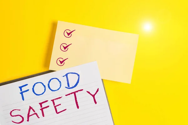 Conceptueel handschrift waaruit de voedselveiligheid blijkt. Business foto tekst voorwaarden en praktijken die de kwaliteit van voedsel te behouden Leeg oranje papier met kopieerruimte op de gele tafel. — Stockfoto