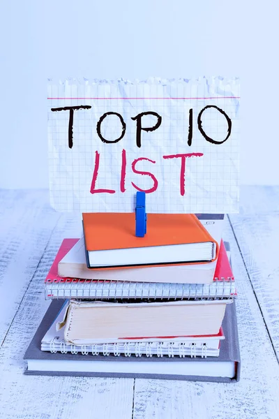 Conceptuele handschrift toont Top 10 Lijst. Zakelijke foto tekst de tien belangrijkste of succesvolle items in een bepaalde lijst stapel gestapelde boeken notebook pin kleur herinnering wit hout. — Stockfoto