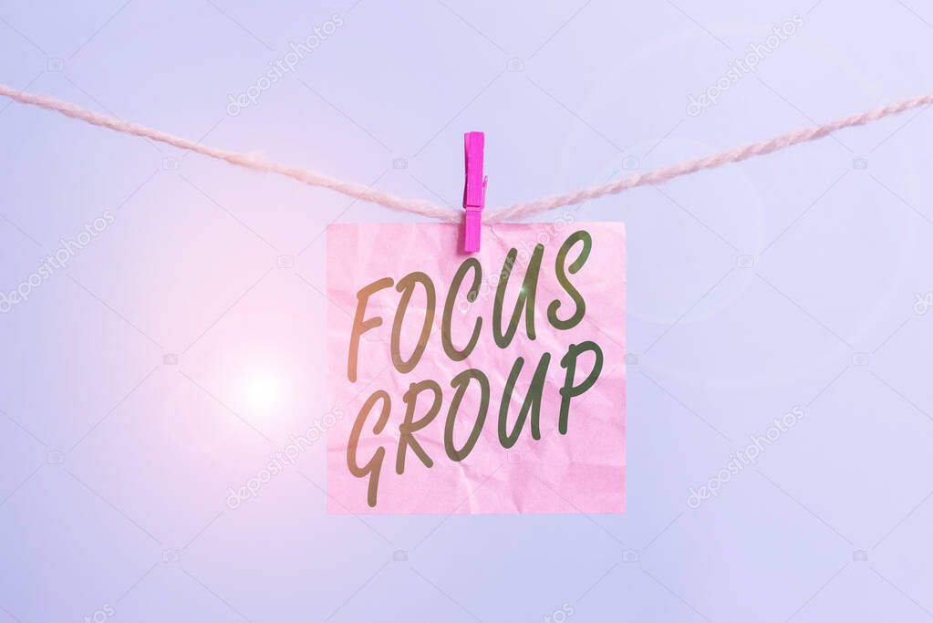 Text sign showing Focus Group. Conceptual photo showing assembled to participate in discussion about something Clothesline clothespin rectangle shaped paper reminder white wood desk.