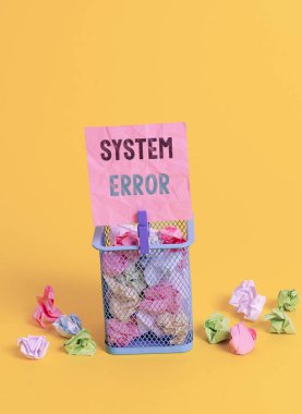 El yazısı yazma Sistem Hatası. Konsept, işletim sistemi tarafından tanınmayan, çöp tenekesi buruşmuş kağıt çamaşır mandalı boş hatırlatıcı ofis malzemeleri sarı.
