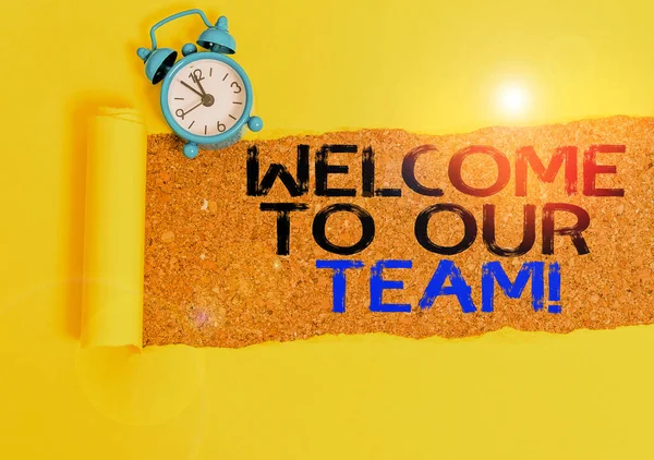Handwriting text writing Welcome To Our Team. Concept meaning introducing another demonstrating to your team mates Alarm clock and torn cardboard placed above a wooden classic table backdrop. — Stock Photo, Image