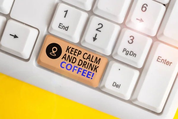 Scrivere una nota che mostra Keep Calm And Drink Coffee. Business photo showcase incoraggiare dimostrando di godere di caffeina bere e rilassarsi Tastiera bianca pc con carta nota sopra lo sfondo bianco . — Foto Stock