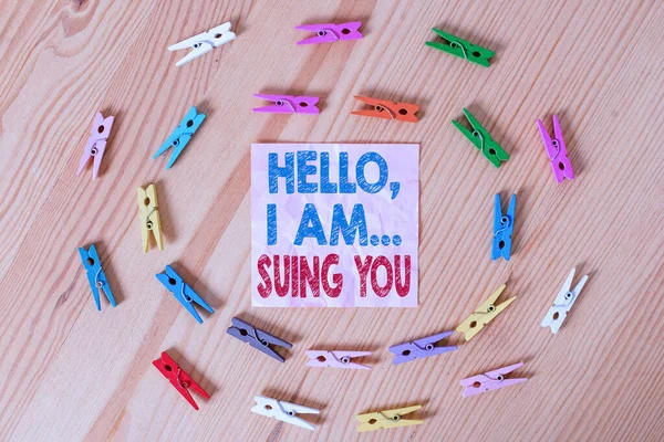 Conceptual hand writing showing Hello I Am Suing You. Business photo text create a case to accuse someone from his actions Colored crumpled papers wooden floor background clothespin.