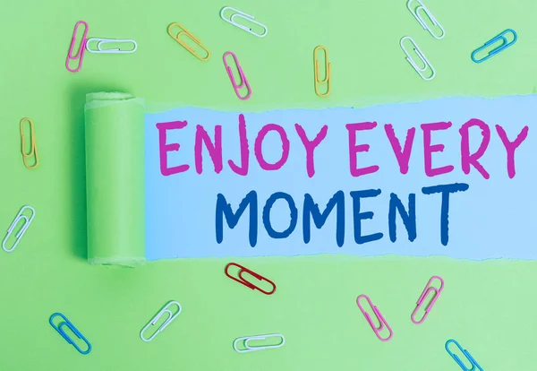 Writing note showing Enjoy Every Moment. Business photo showcasing being pleased with your life Have fun Precious time Paper clip and torn cardboard on wood classic table backdrop. — 图库照片