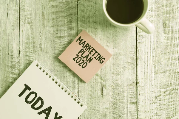 Word writing text Plan de Marketing 2020 Concepto de negocio para el calendario que define el camino de venta de la marca en el próximo año Estacionario colocado junto a una taza de café negro sobre la mesa de madera . — Foto de Stock