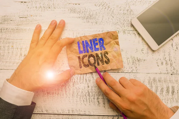 Conceptual hand writing showing Liner Icons. Business photo showcasing use to improve visual interest and grab the user s is attention Hand hold note paper near writing equipment and smartphone.