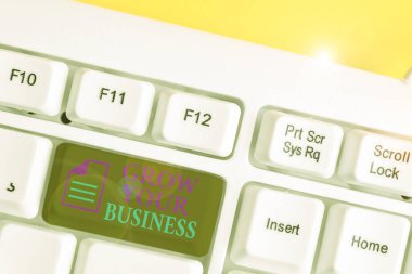 İşinizi Büyütün 'ü gösteren bir not yazıyorum. İş fotoğrafı gösterimi daha fazla kar elde etmek için yatırımların daha iyi iadesini sağlayın Beyaz pc klavye beyaz arkaplanın üzerinde not kağıdı ile birlikte.