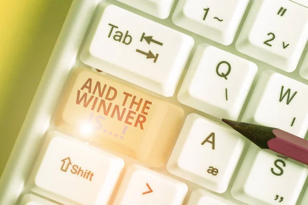 Zobrazí se textové znaménko a vítěz je. konceptuální fotografie oznamující, kdo dostal první místo na soutěži nebo zkoušku klávesnice White PC s prázdným papírovým papírem nad bílou kopií klíče pozadí. — Stock fotografie