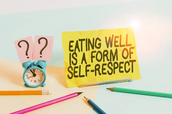 Text sign showing Eating Well Is A Form Of Self Respect. Conceptual photo a quote of promoting healthy lifestyle Mini size alarm clock beside stationary placed tilted on pastel backdrop.
