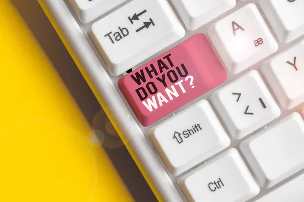 Text sign showing What Do You Want Question. Conceptual photo say or write in order to ask demonstrating about something White pc keyboard with empty note paper above white background key copy space.