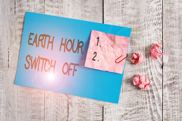 Word writing text Earth Hour Switch Off. Business concept for The Lights Out Event Annual Movement Planet Day Wrinkle paper and cardboard plus stationary placed above wooden background.