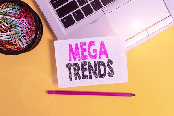 Conceptual hand writing showing Mega Trends. Business photo text powerful phenomena impacting the foundations of our world Trendy laptop pencil squared paper container colored background. — 스톡 사진