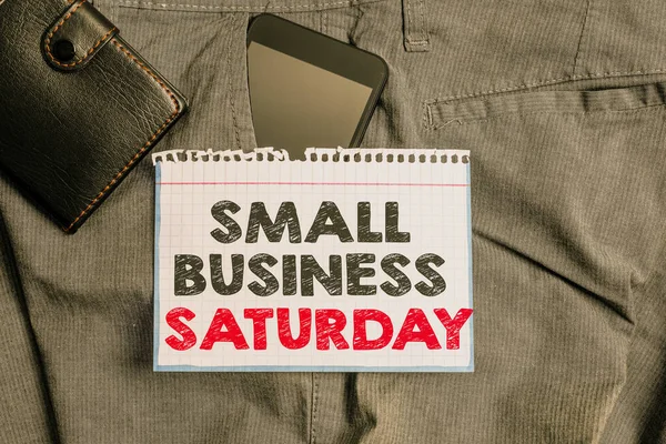 Escrevendo uma nota mostrando Small Business Saturday. Foto de negócios mostrando feriado americano de compras realizadas durante o sábado Smartphone dispositivo dentro de calças bolso frontal com carteira . — Fotografia de Stock