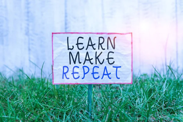 Signo de texto que muestra Learn Make Repeat. Foto conceptual Una vez que lo hagas será fácil aprender rápido corregir errores Papel arrugado adjunto a un palo y colocado en la tierra verde cubierta de hierba . —  Fotos de Stock