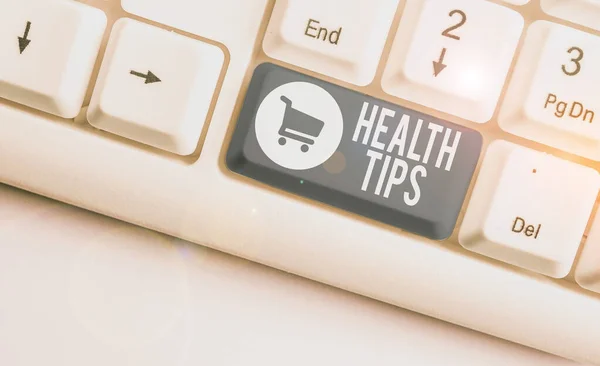 Writing note showing Health Tips. Business photo showcasing beneficial to one s is physical mental or emotional state White pc keyboard with note paper above the white background.