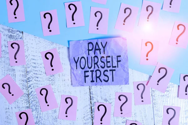 Text sign showing Pay Yourself First. Conceptual photo Saving for future Setting aside a Portion of your income Scribbled and crumbling papers with thick cardboard above wooden table.