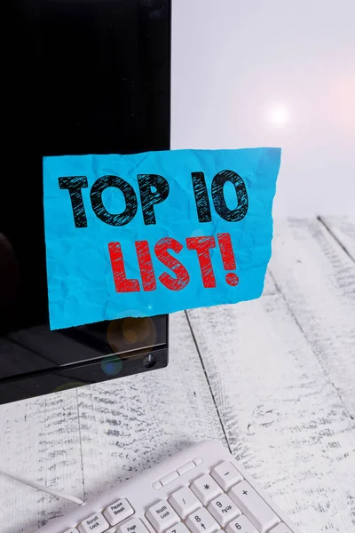 Χειρόγραφο κείμενο Top 10 Λίστα. Έννοια που σημαίνει τα δέκα πιο σημαντικά ή επιτυχημένα στοιχεία σε μια συγκεκριμένη λίστα Χαρτί σημειώσεων κολλημένο στη μαύρη οθόνη του υπολογιστή κοντά στο λευκό πληκτρολόγιο. — Φωτογραφία Αρχείου