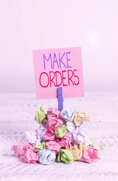 Writing note showing Make Orders. Business photo showcasing A confirmed request by one party to another to buy or sell Reminder pile colored crumpled paper clothespin wooden space.